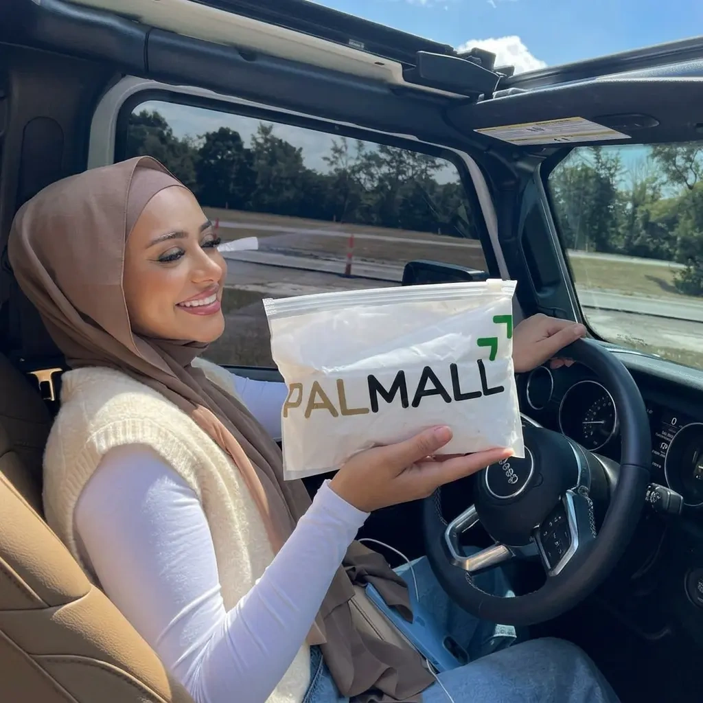 Conductrice tenant le pack PALMALL dans sa voiture